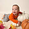 baby, child, smiling, autumn, pumpkins, orange_shirt, striped_pants, zebra_stripes, indoor, portrait, crawling, happy, infant, face, playful, fall_leaves, blanket, seasonal_decor, still_life, photography