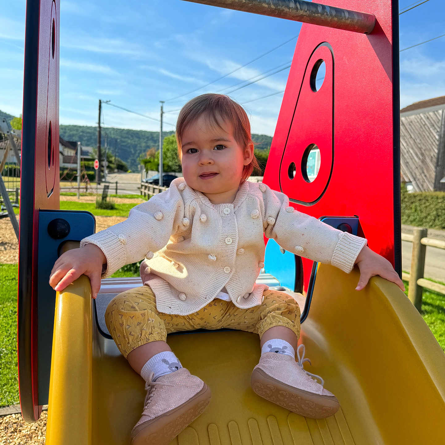 Lou participe au concours pour gagner de l'argent avec cette photo : building, child, clothing, daylight, fence, grass, happy, nature, outdoor, person, play, playground, red, shoes, sky, slide, socks, sunny, toddler, yellow