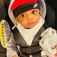 Lennox joined the competition — help win amazing prizes! baby, child, car_seat, seat_belt, hoodie, hat, headband, nike, clothing, infant, hand, knit_cap, safety, warning_label, person, portrait, indoors, cute, expression, closeup