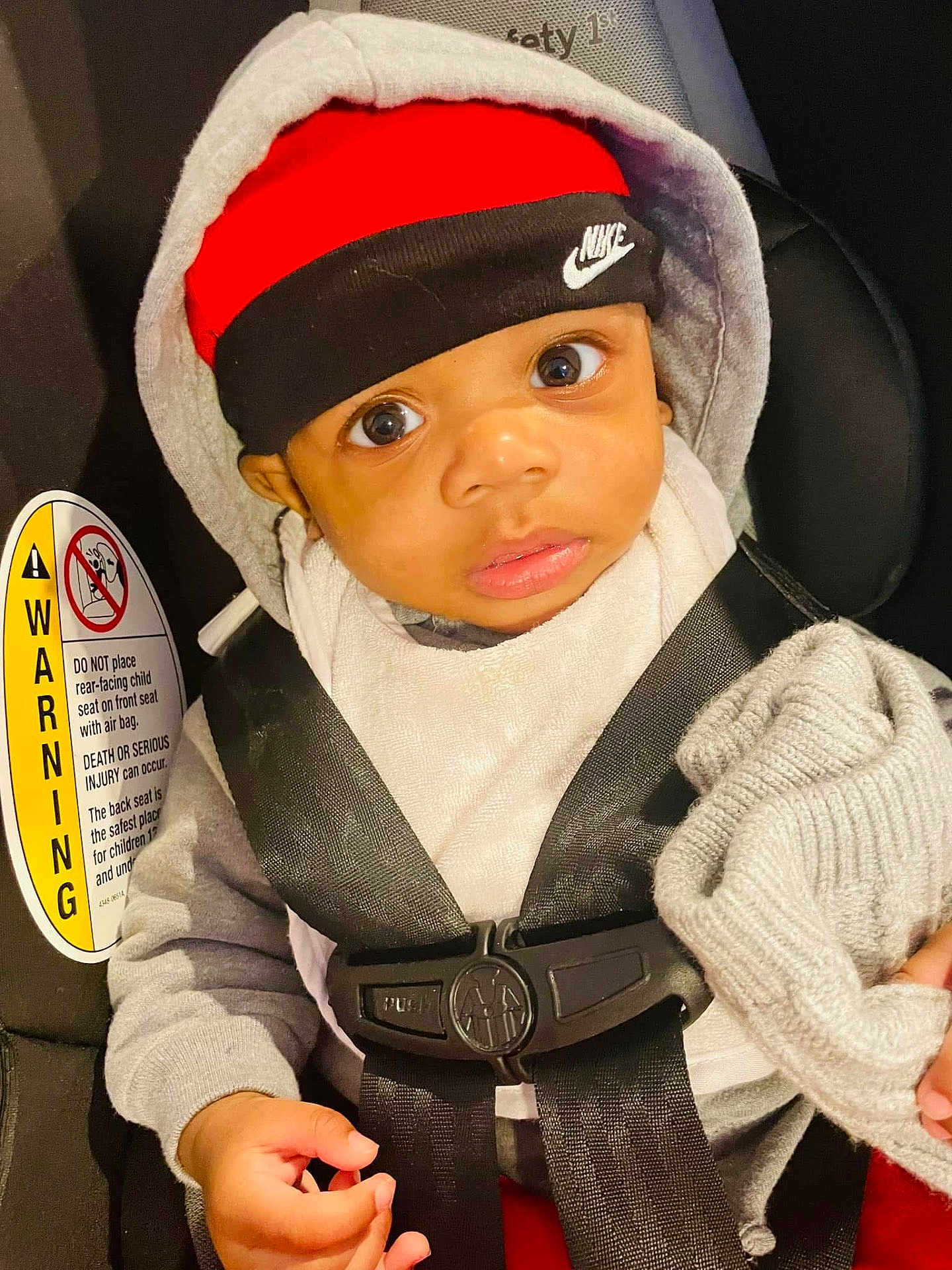 Lennox joined the competition — help win amazing prizes! baby, child, car_seat, seat_belt, hoodie, hat, headband, nike, clothing, infant, hand, knit_cap, safety, warning_label, person, portrait, indoors, cute, expression, closeup