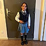 Sarah participe au concours pour gagner de l'argent avec cette photo : child, girl, standing, indoors, school_uniform, vest, tie, pleated_skirt, braided_hair, black_shoes, knee_socks, door, wall, floor, confident, pose, portrait, young, fashion, casual