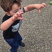 Zeeland is registered to the contest to win money with this photo: active, background, black_shirt, boy, casual_clothing, child, daylight, fun, giant_egg, jeans, motion, outdoor, pavement, person, playful, reaching, short_hair, sneakers, toy_prop, young