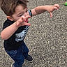 active, background, black_shirt, boy, casual_clothing, child, daylight, fun, giant_egg, jeans, motion, outdoor, pavement, person, playful, reaching, short_hair, sneakers, toy_prop, young