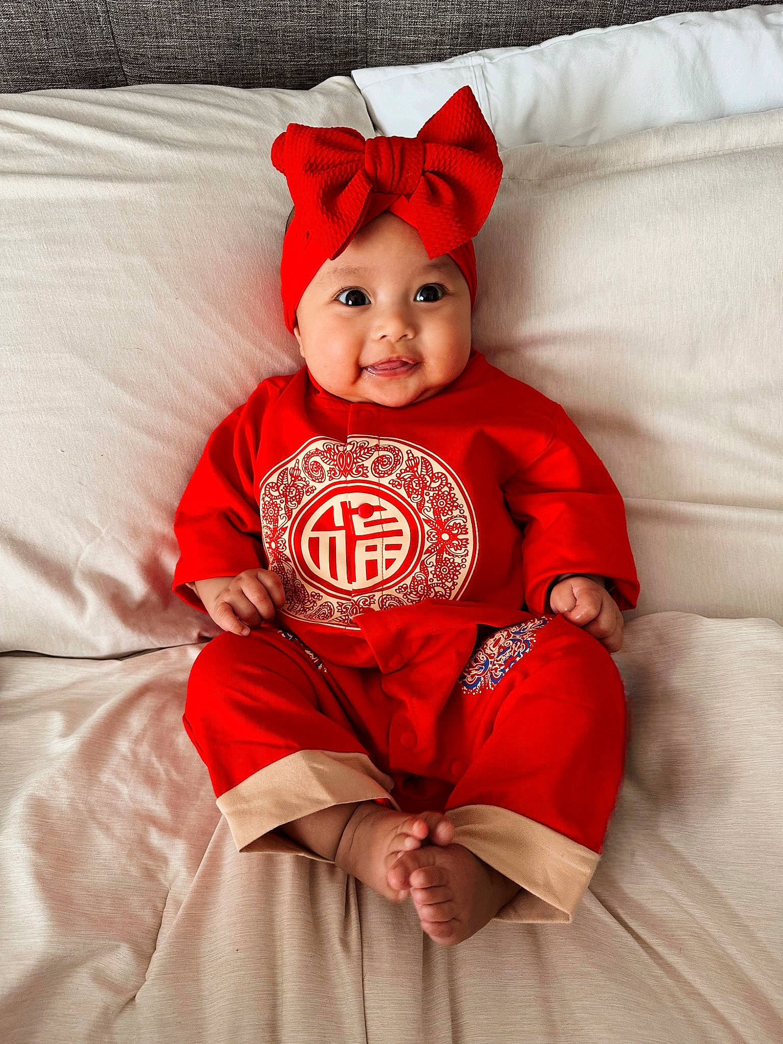 Emma joined the competition — help win amazing prizes! baby, baby_toddler_clothing, cap, child, comfort, costume_hat, fictional_character, fur, happy, hat, headgear, headwear, linens, person, pillow, red, sleeve, smile, t_shirt, textile