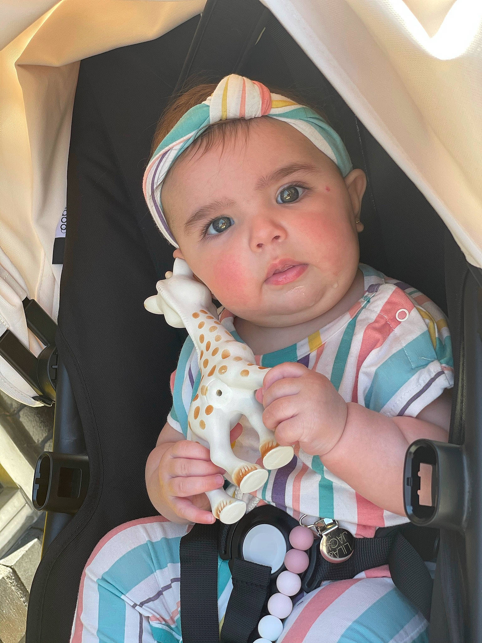 Meadow is registered to the contest to win money with this photo: arm, auto_part, baby, baby_carriage, baby_safety, baby_toddler_clothing, cap, child, electric_blue, eye, hand, headwear, nail, person, pink, product, skin, sleeve, textile, thumb