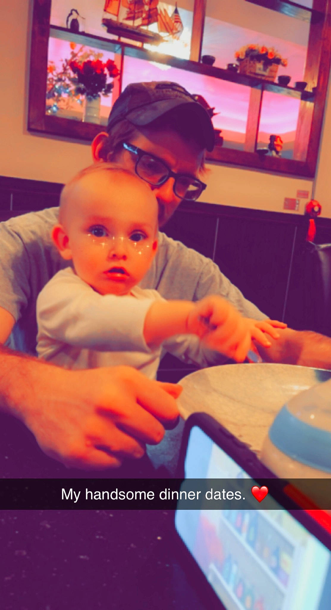 Paxton joined the competition — help win amazing prizes! baby, baseball_cap, cap, child, comfort, electronic_device, event, eyewear, finger, fun, happy, headwear, lap, person, picture_frame, room, sitting, snapshot, t_shirt, television