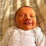 Blake is registered to the contest to win money with this photo: baby, newborn, infant, smiling, face, closed_eyes, white_clothing, onesie, blanket, soft_texture, sleeping, peaceful, child, human, portrait, cute, indoors, resting, skin, head
