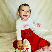 Ivonne is registered to the contest to win money with this photo: baby, blanket, cap, child, clothing, cute, face, foot, hand, happy, hat, in_n_out_burger, indoor, person, portrait, red_skirt, sitting, smile, white_top, young