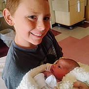 Jordyn is registered to the contest to win money with this photo: child, newborn, baby, hospital, blanket, smile, freckles, red_hair, indoor, person, holding, face, happy, portrait, newborn_baby, hospital_room, clothing, bed, blanket_wrap, toddler