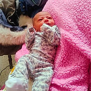 Jordyn joined the competition — help win amazing prizes! baby, newborn, infant, blanket, pink, cozy, sleepwear, soft, cute, child, patterned_clothing, lying_down, indoors, warm, resting, small, adorable, face, head, footwear