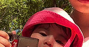 Khealani is registered to the contest to win money with this photo: adult, baby, casual, child, closeup, daylight, face, hand, hat, holding, keychain, nature, outdoor, person, pink_hat, portrait, sky, summer, sunlight, trees
