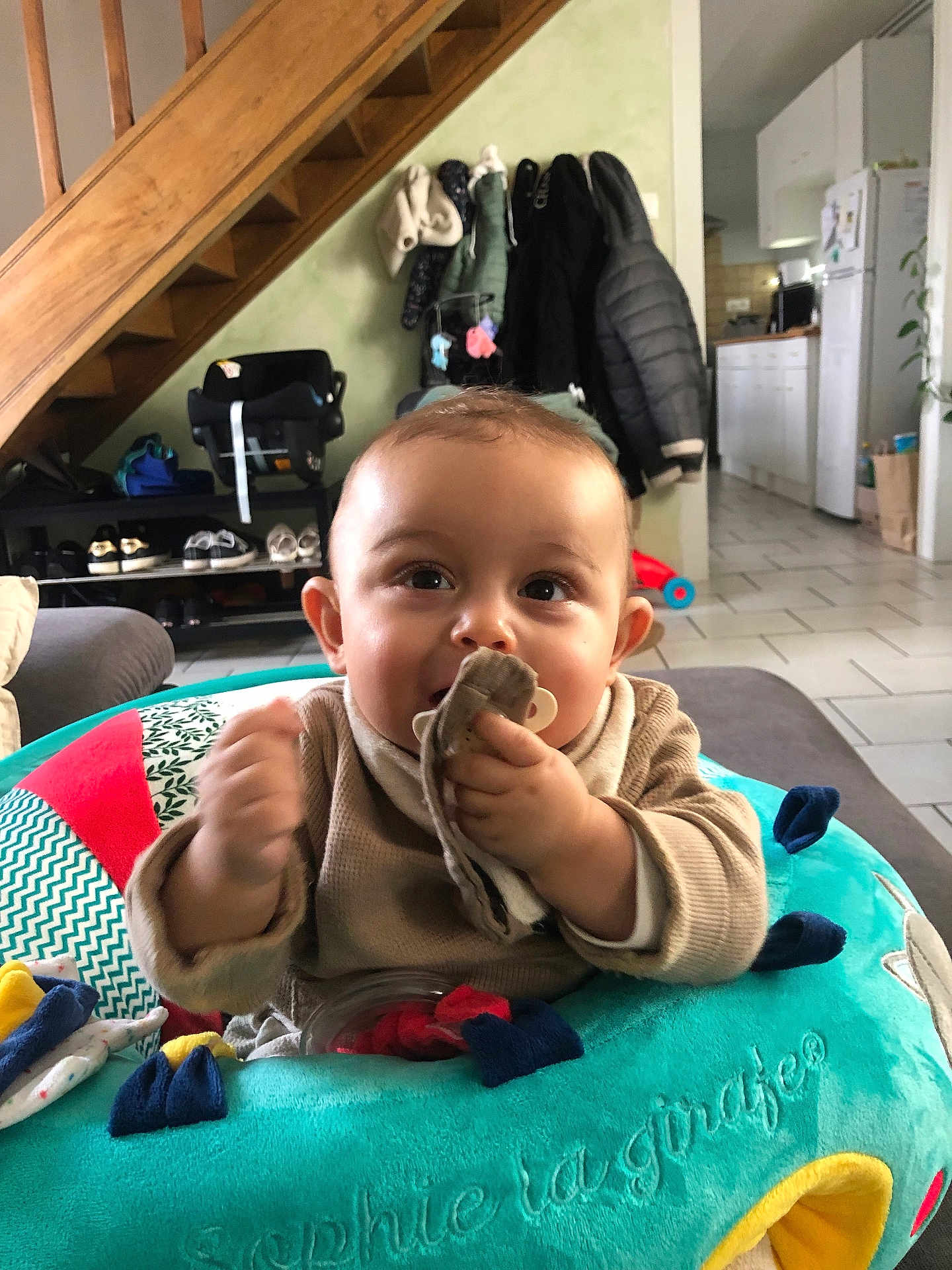 Neìss a rejoint le concours — aidez-le/la à gagner de superbes lots ! activity_ring, baby, child, clothing, coat, cute, face, furniture, hand, household, indoor, infant, kitchen, living_room, pacifier, plush_toy, shoes, smiling, stairs, tile_floor