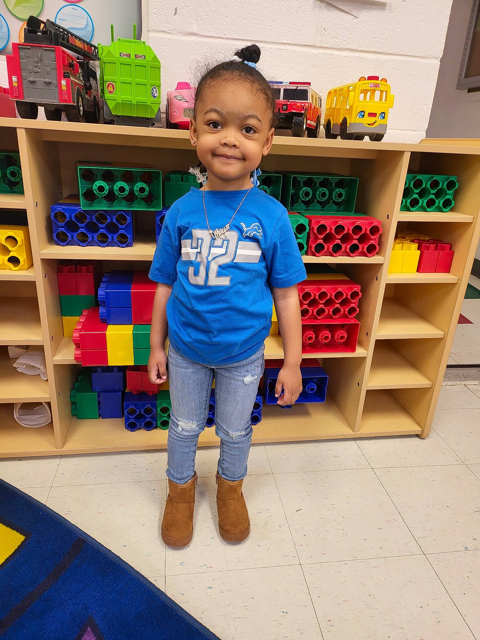 Morgan is registered to the contest to win money with this photo: baby_toddler_clothing, child, denim, electric_blue, floor, flooring, footwear, fun, happy, joy, person, retail, shelf, shelving, shoe, smile, sneakers, standing, t_shirt, toddler