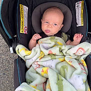 Leroy is registered to the contest to win money with this photo: baby, car_seat, blanket, outdoor, infant, child, tongue, expression, playful, safety_warning, fabric, seatbelt, person, cute, bundle, colorful, soft, head, face, car