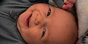 Leroy is registered to the contest to win money with this photo: baby, smiling, blanket, cozy, infant, cute, child, sleepwear, soft, happy, lying_down, indoors, colorful, playful, warm, comfort, portrait, face, expression, toddler