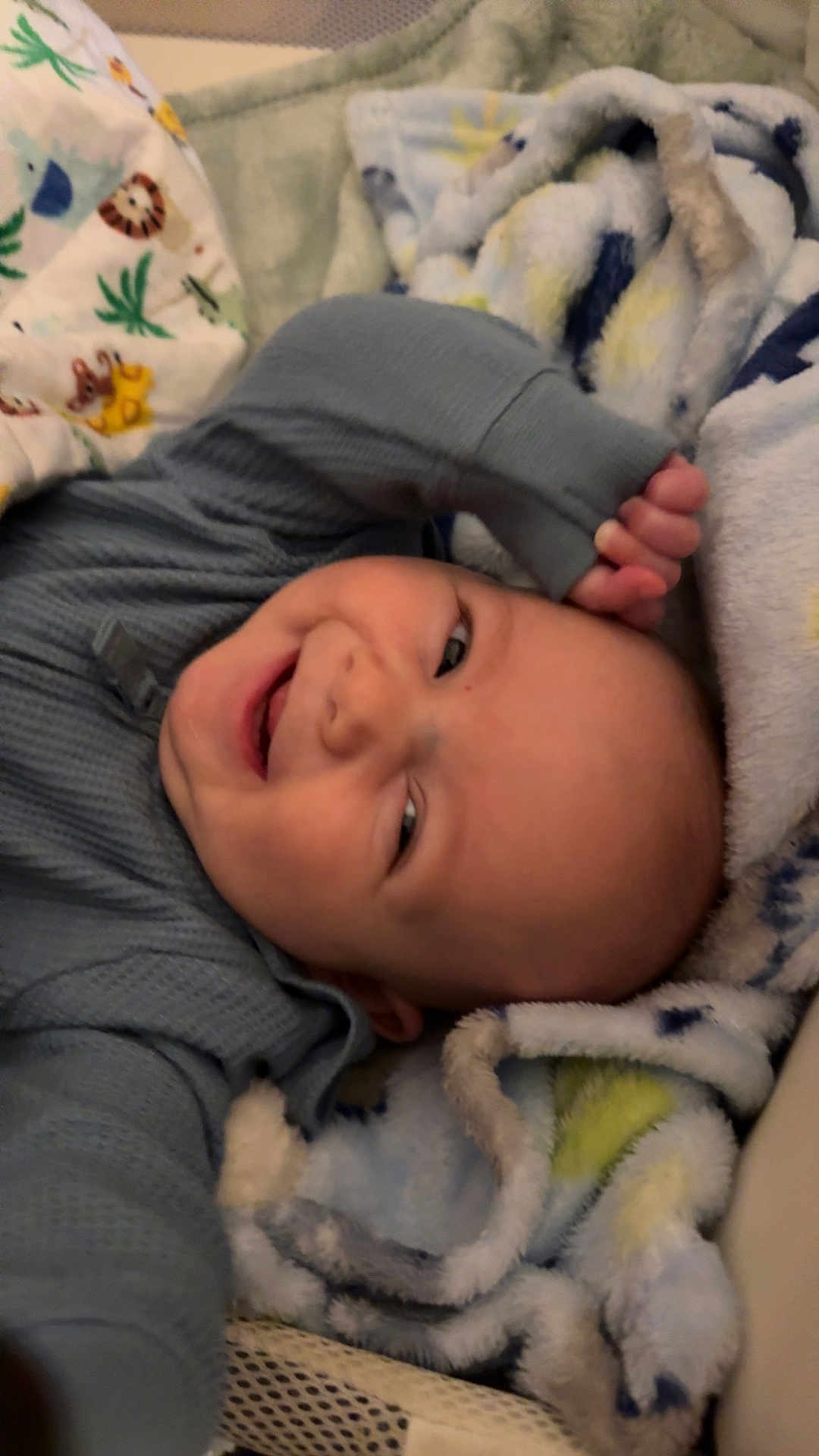 Leroy is registered to the contest to win money with this photo: baby, smiling, blanket, cozy, infant, cute, child, sleepwear, soft, happy, lying_down, indoors, colorful, playful, warm, comfort, portrait, face, expression, toddler
