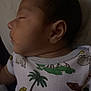 Jose Antonio is registered to the contest to win money with this photo: baby, sleeping, infant, onesie, animal_print, peaceful, portrait, closeup, child, face, ear, head, clothing, palm_tree, rhino, elephant, leopard, indoor, rest, calm