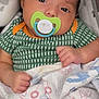baby, infant, pacifier, blanket, patterned_clothing, green_shirt, hand, face, eyes, indoor, cute, sleepy, newborn, child, soft, cozy, portrait, resting, baby_boy, closeup
