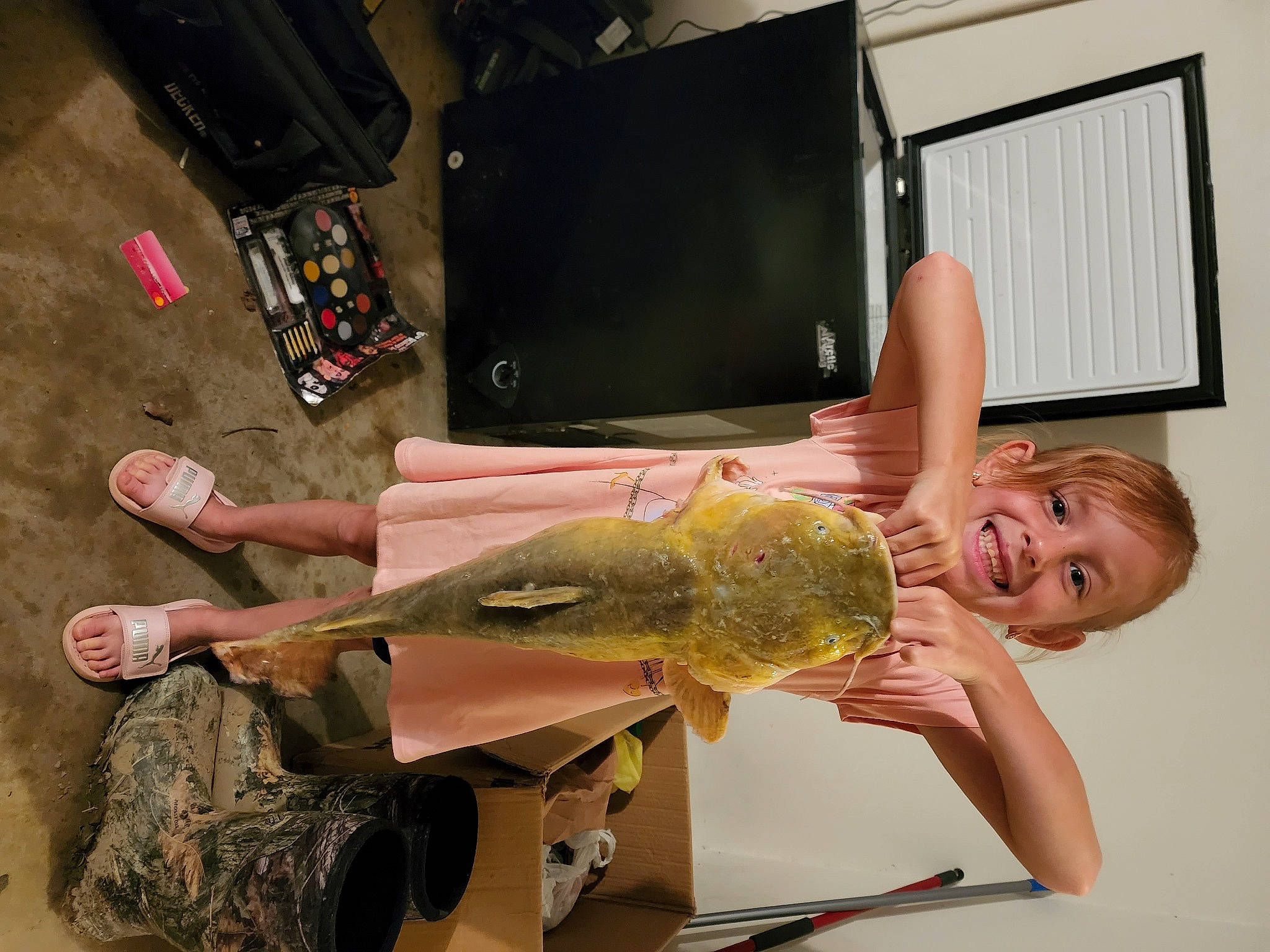 Elena is registered to the contest to win money with this photo: fin, fish, foot, fun, gesture, home_appliance, human_leg, joint, joy, machine, person, picture_frame, recreation, room, shorts, shoulder, smile, t_shirt, television, thigh