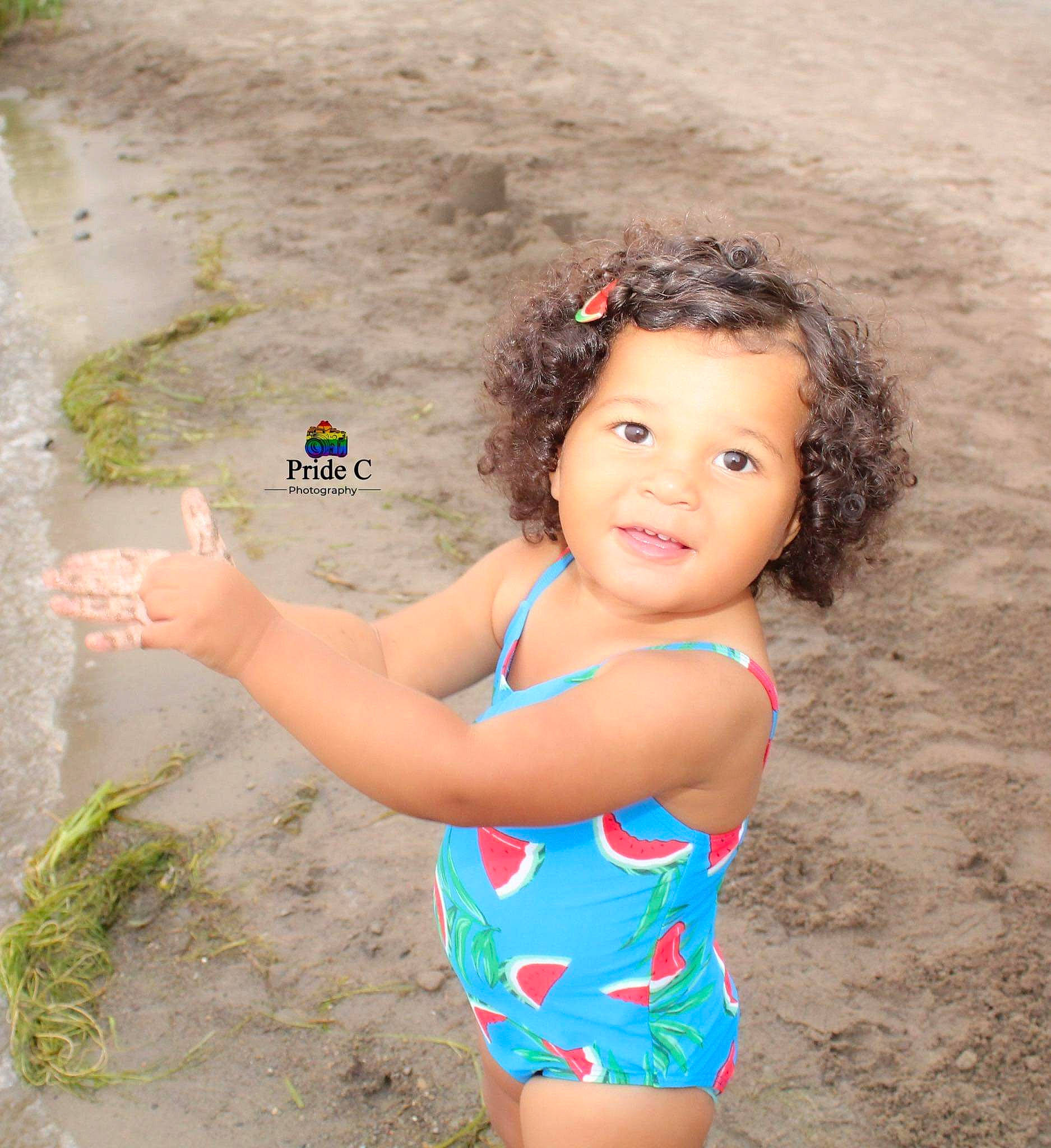 Paris is registered to the contest to win money with this photo: arm, beach, beauty, blond, body_of_water, chest, child, electric_blue, fun, happy, leisure, people_in_nature, person, photograph, sand, skin, summer, swimwear, thigh, toddler