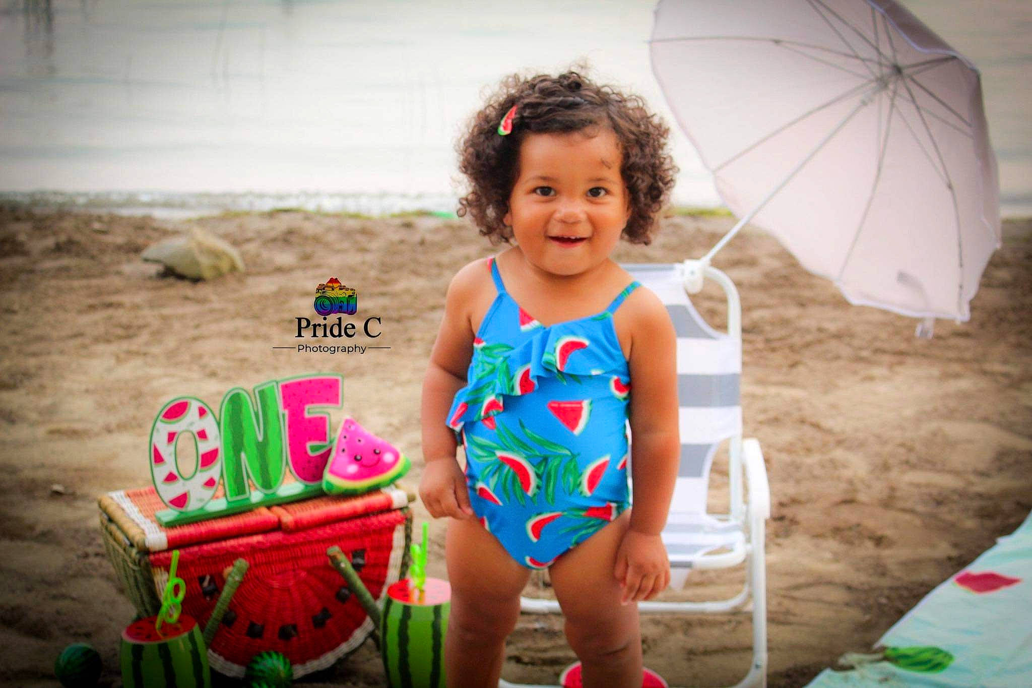 Paris is registered to the contest to win money with this photo: beach, child, eye, facial_expression, flash_photography, fun, happy, human, joy, leisure, people_in_nature, people_on_beach, person, pink, recreation, smile, summer, swimwear, thigh, toddler