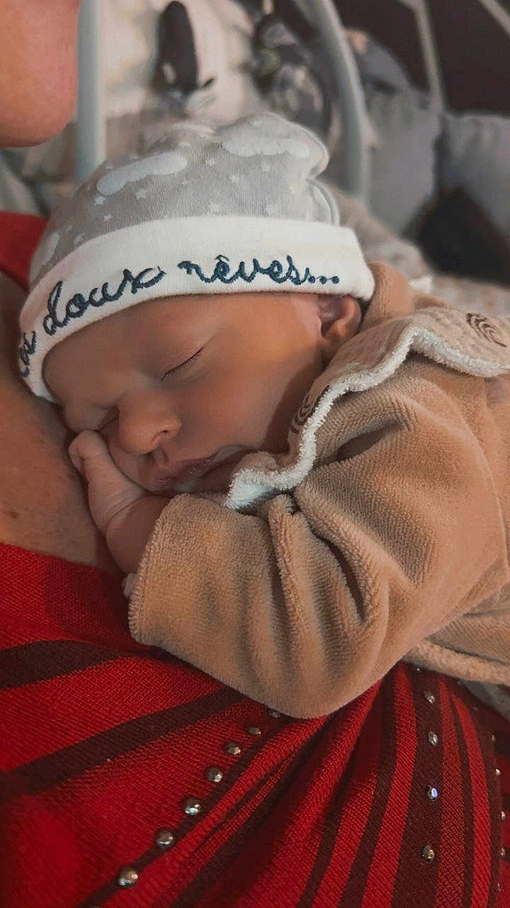 Baptiste participe au concours pour gagner de l'argent avec cette photo : animal, baby, bird, blanket, bonnet, cap, clothing, face, glove, hat, head, kissing, newborn, penguin, person, photography, portrait, quilt, romantic, sleeping