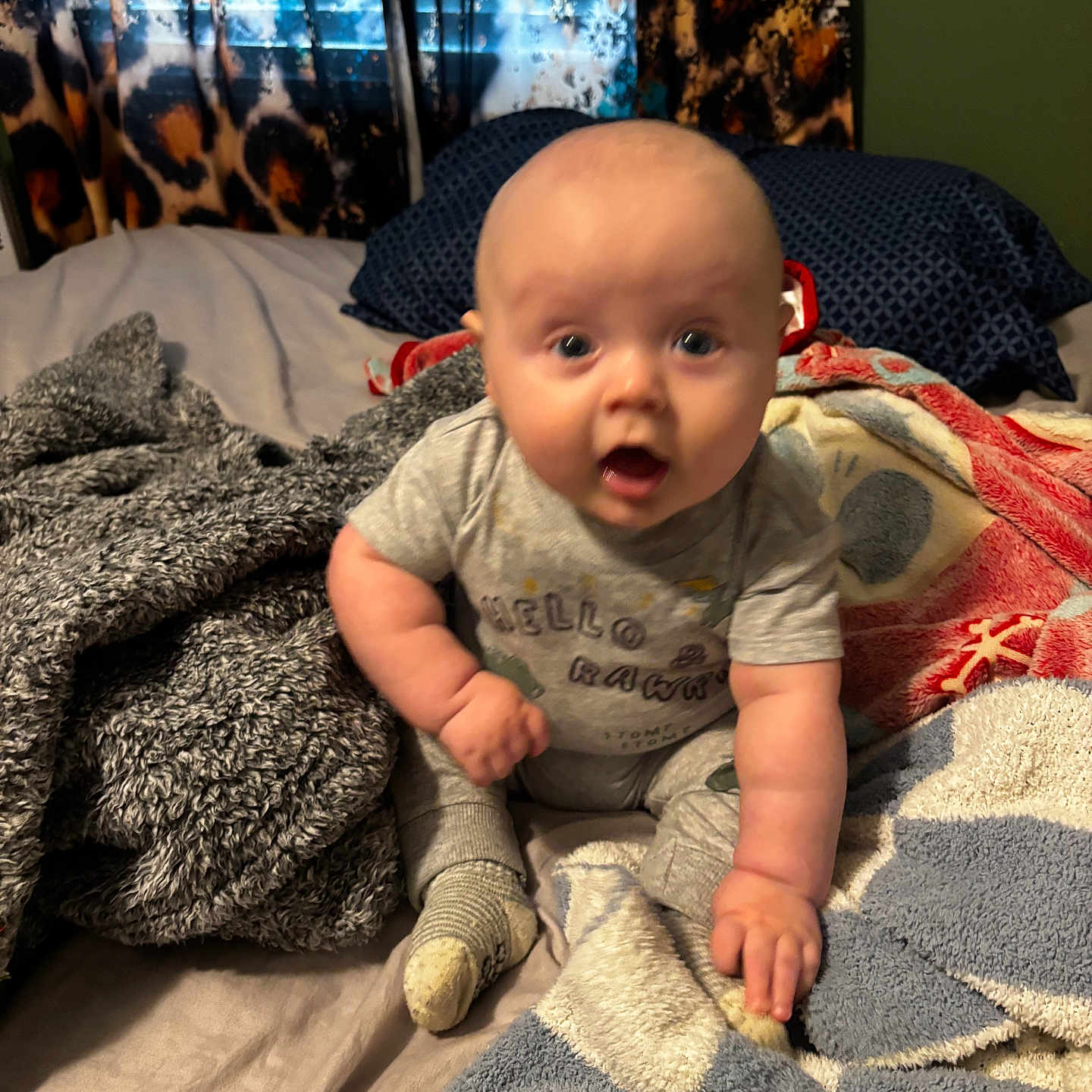 Kannyn joined the competition — help win amazing prizes! baby, bed, bedding, blanket, child, cozy, curtain, eyes, face, indoor, infant, mouth_open, onesie, pillow, plush, portrait, sitting, sock, soft_texture, surprised_expression