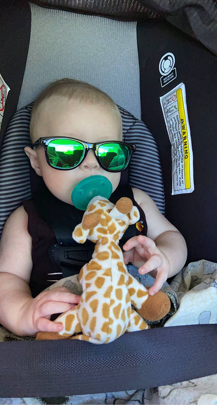 Xander is registered to the contest to win money with this photo: baby_toddler_clothing, child, cool, eyewear, fawn, finger, giraffe, giraffidae, glasses, goggles, head, human, mouth, nose, person, product, sunglasses, thumb, toddler, toy