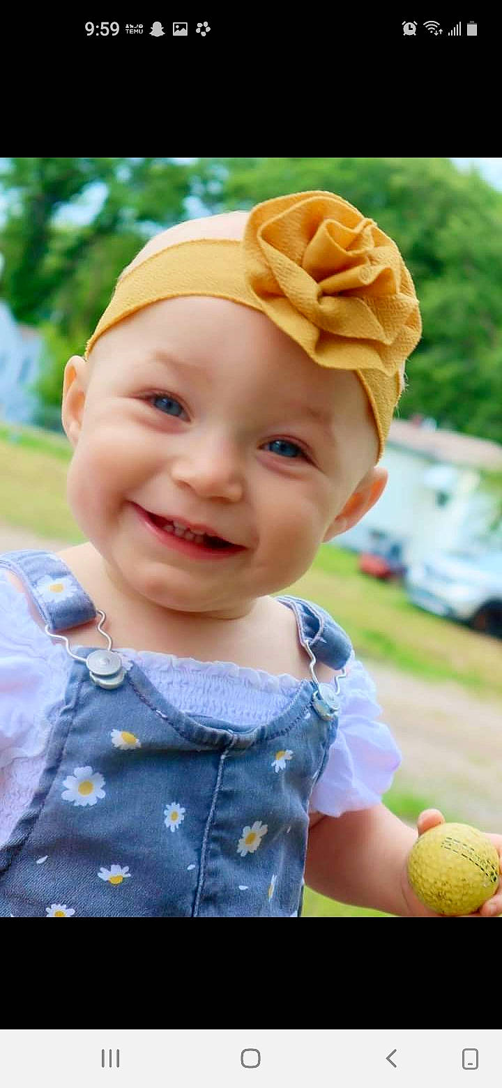Scarlett is registered to the contest to win money with this photo: baby, baby_toddler_clothing, blond, cap, child, eye, fun, grass, happy, headwear, iris, joy, leisure, lip, pattern, person, pink, plant, skin, smile