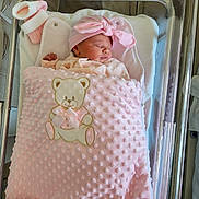 Judy a rejoint le concours — aidez-le/la à gagner de superbes lots ! newborn, baby, blanket, pink, teddy_bear, headband, bow, sleeping, hospital, bassinet, crib, infant, clothing, soft, cute, resting, cozy, child, person, indoors