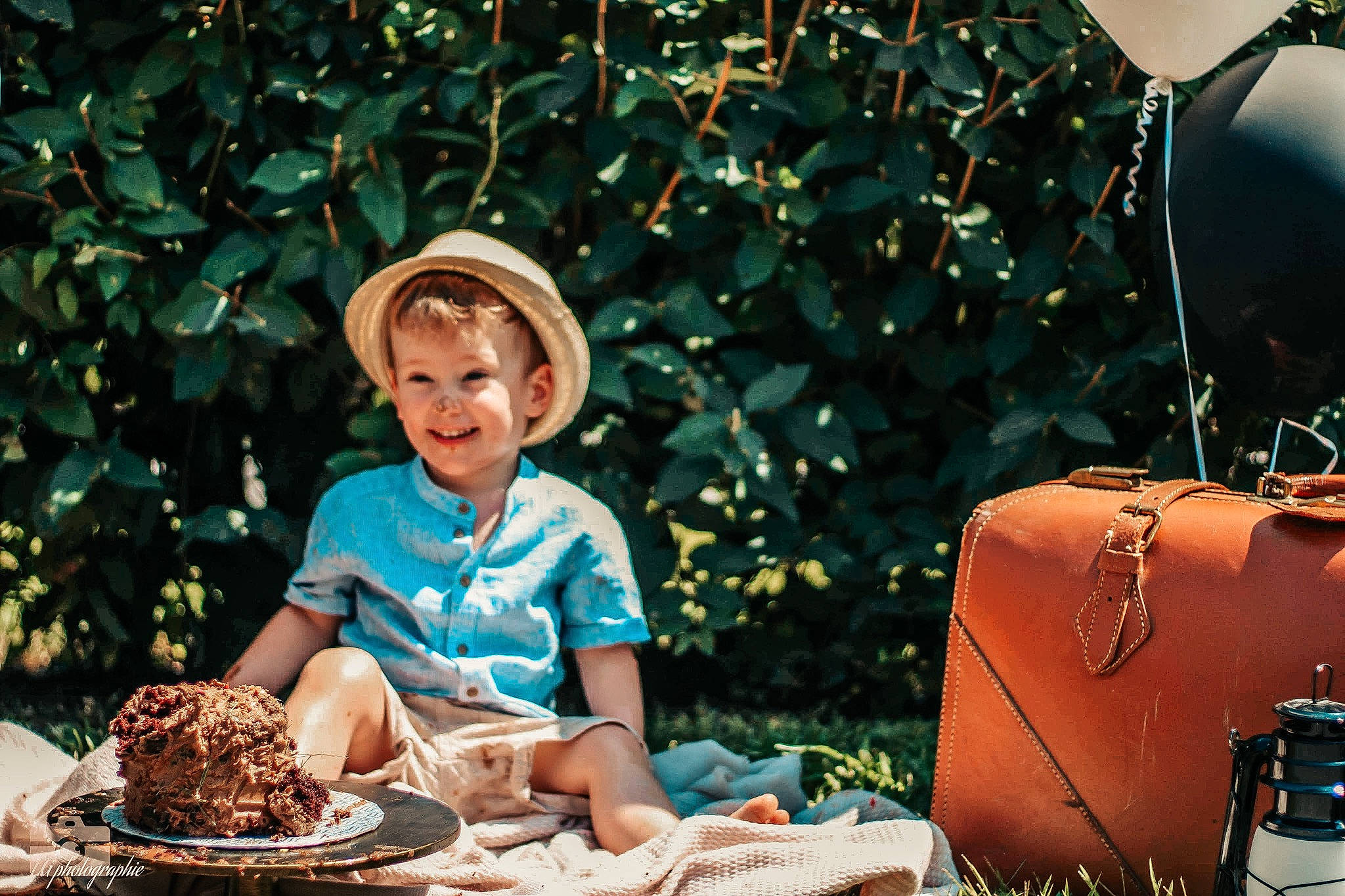 Jessy a rejoint le concours — aidez-le/la à gagner de superbes lots ! bag, child, event, fun, grass, green, happy, hat, joy, leisure, luggage_and_bags, people, people_in_nature, person, plant, shoulder_bag, sitting, smile, summer, sun_hat