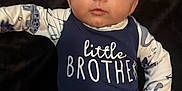 Waylon joined the competition — help win amazing prizes! baby, infant, child, face, blue_clothing, pajamas, dinosaur_print, lying_down, hand, expression, portrait, young, cute, childrens_clothing, sleeves, rope_belt, dark_background, looking, person, skin