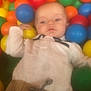 baby, child, ball_pit, colorful, balls, toy, play, indoor, casual_clothing, pants, shirt, infant, soft_focus, calm, portrait, person, cute, leisure, relaxation, young