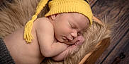 Aerilyn joined the competition — help win amazing prizes! baby, closeup, cozy, cute, face, fur_blanket, hand, hat, indoors, infant, knit_hat, newborn, peaceful, portrait, resting, skin, sleeping, soft_lighting, wooden_box, yellow_hat