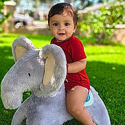Ismael joined the competition — help win amazing prizes! baby, child, cute, elephant, grass, greenery, happy, infant, nature, one_year_old, outdoor, park, person, playful, plush_toy, red_clothing, smiling, summer, sunlight, toy