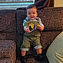 Ismael is registered to the contest to win money with this photo: baby, brown, child, clothing, couch, curtains, cute, face, footwear, furniture, happy, home, indoor, overalls, person, smiling, socks, toddler, toy, window