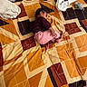 Lakshmi is registered to the contest to win money with this photo: baby, bedroom, blanket, carpet, child, clothing, cute, fabric, floor, geometric, indoor, infant, nap, pattern, pink_pants, plush, purple_shirt, relaxation, sleeping, toy