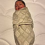 Autumn is registered to the contest to win money with this photo: baby, infant, swaddle, blanket, mattress, pattern, sleeping, happy, child, face, cute, newborn, bed, soft, cozy, lying_down, person, indoors, skin, smile