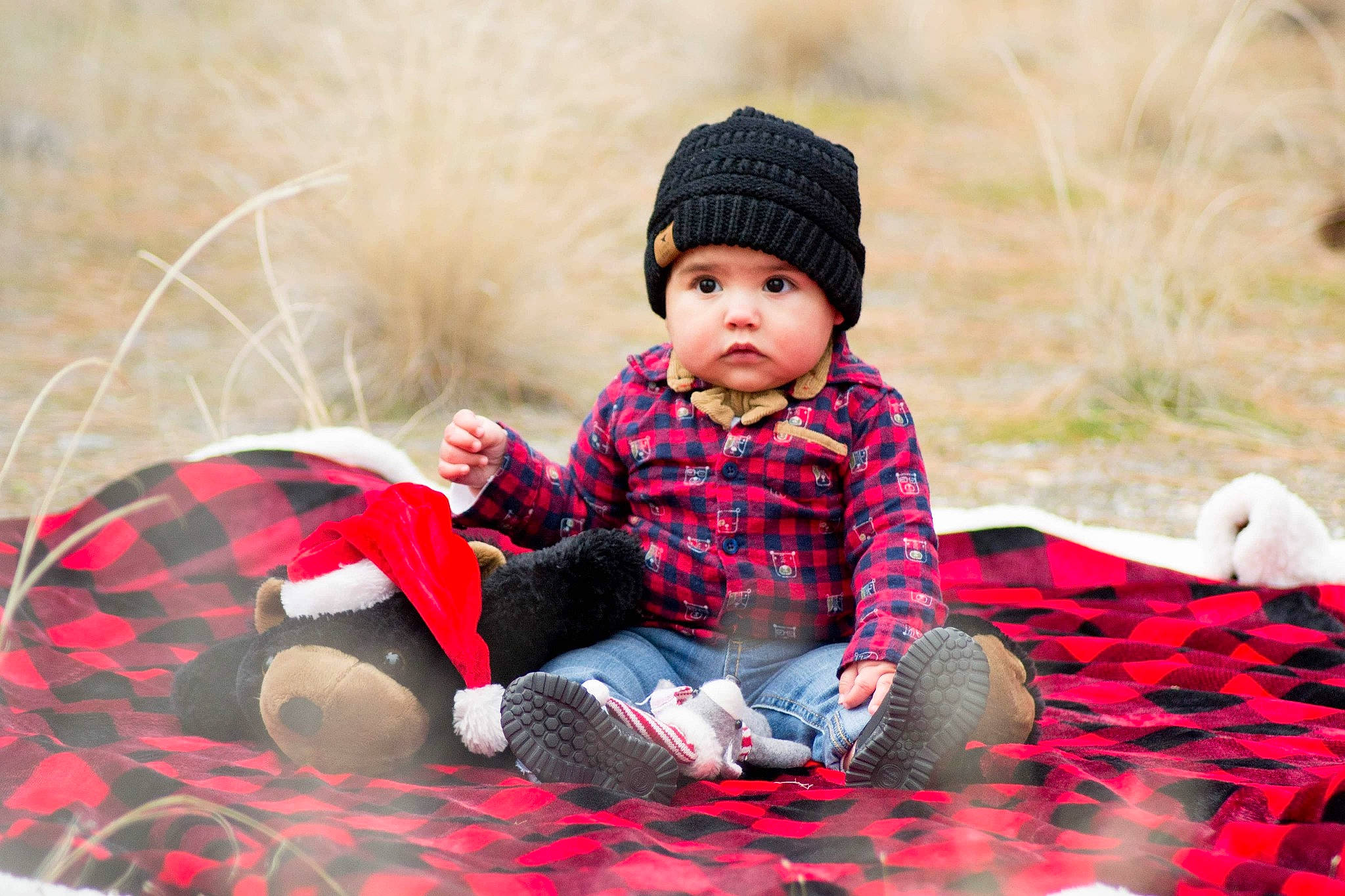 Oscar Jr. is registered to the contest to win money with this photo: baby, beanie, cap, child, headgear, knit_cap, knitting, pattern, person, photography, plaid, play, portrait_photography, red, sitting, tartan, textile, toddler, wool