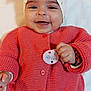 baby, smiling, headband, pink_sweater, button, hand, infant, cute, lying_down, happy, face, skin, clothing, knitted, person, child, cozy, accessory, soft, portrait