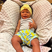 Jaxlynn joined the competition — help win amazing prizes! baby, smiling, headband, yellow, shorts, blue, yellow_dots, baby_seat, blanket, indoors, carpet, child, happy, cute, infant, clothing, person, portrait, relaxed, soft