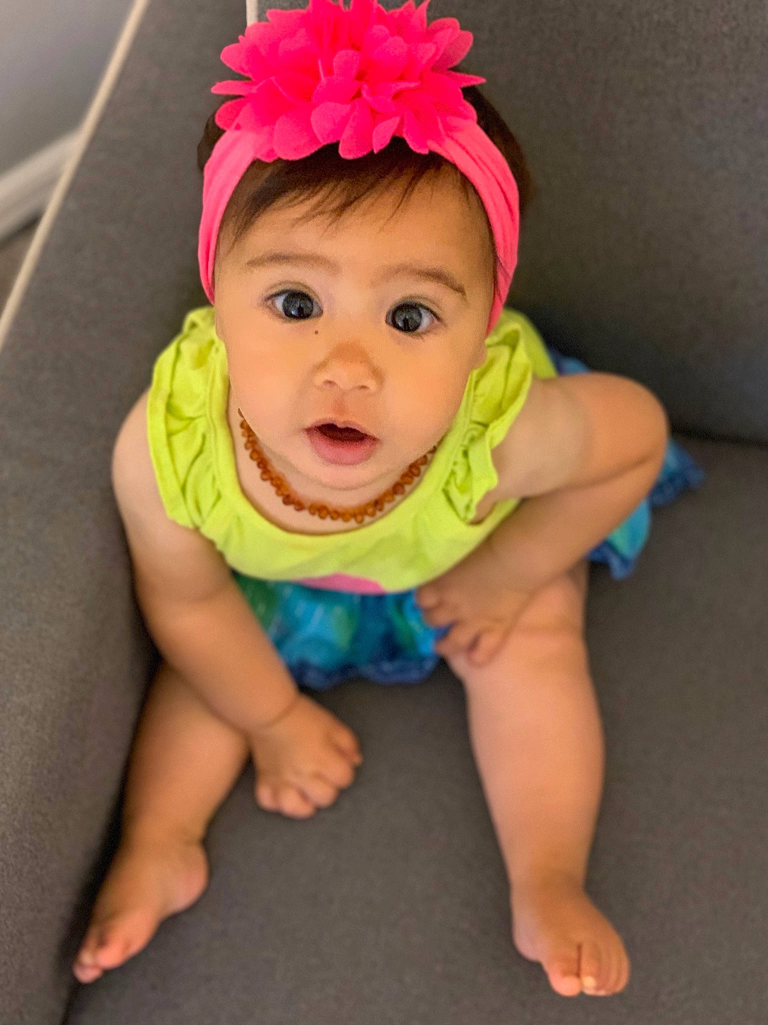 Mia is registered to the contest to win money with this photo: baby, baby_toddler_clothing, cap, child, clothing, dress, eye, face, grass, happy, head, headband, headgear, headpiece, person, petal, pink, plant, skin, sleeve