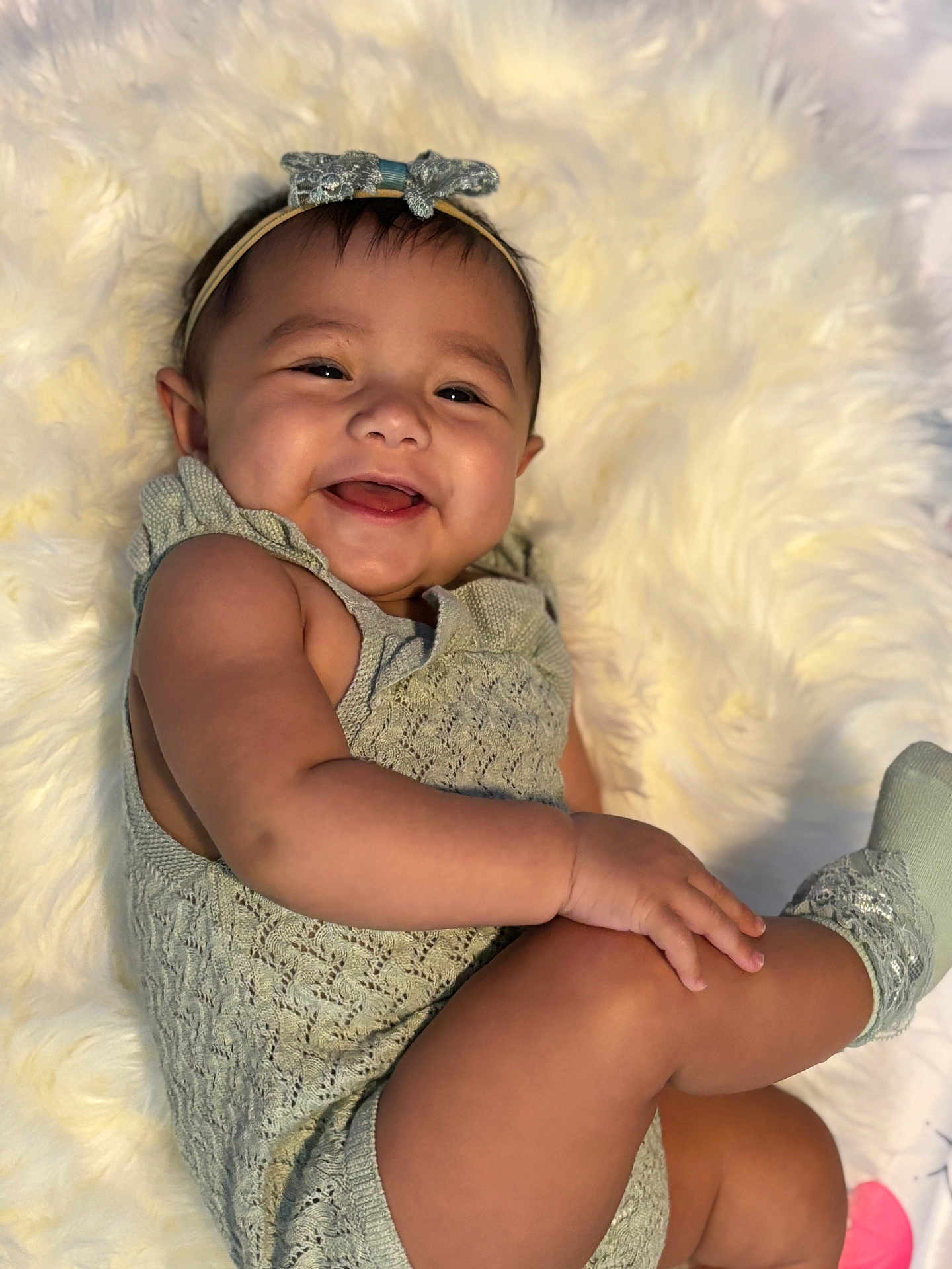 Alivia is registered to the contest to win money with this photo: baby, blanket, child, clothing, cozy, cute, face, hand, happy, headband, indoor, infant, leg, one_person, portrait, relaxing, skin, smiling, sock, soft_texture