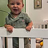 Wesley joined the competition — help win amazing prizes! baby, child, crib, face, furniture, green_shirt, handrail, happy, indoor, nursery, person, picture_frame, plaid, room, shorts, smile, standing, toddler, toy, wall_art