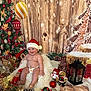 baby, santa_hat, diaper, christmas_tree, ornaments, plush_toy, holiday_decor, wooden_background, festive, pine_cone, lantern, stuffed_animal, smiling, chair, red_and_white, tinsel, snowflake, christmas_lights, celebration, indoor
