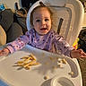 baby, child, high_chair, infant, smiling, happy, sitting, portrait, face, eyes, pink_sweater, long_hair, food, snacks, puff_snacks, feeding, tray, indoor, home, fan