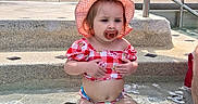 Brayleanna joined the competition — help win amazing prizes! child, toddler, baby, girl, swimming_pool, water, sunhat, pacifier, gingham, pink_clothing, outdoor, summer, poolside, sitting, portrait, face, brown_hair, frowning, stone_steps, handrail
