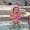 child, toddler, baby, girl, swimming_pool, water, sunhat, pacifier, gingham, pink_clothing, outdoor, summer, poolside, sitting, portrait, face, brown_hair, frowning, stone_steps, handrail