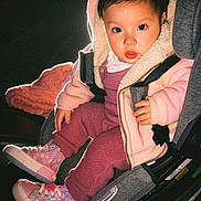Nicole Hernandez is registered to the contest to win money with this photo: toddler, child, car_seat, hooded_jacket, pink_clothing, sneakers, indoor, portrait, baby, seated, cute, warm_clothing, footwear, looking_at_camera, young_child, infant, casual_wear, baby_shoes, seat_belt, cozy
