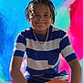 Braxton joined the competition — help win amazing prizes! child, boy, braids, chain_necklace, striped_shirt, blue_shirt, orange_object, colorful_background, portrait, smile, casual_clothing, indoor, young, person, fashion, confident, happy, holding, seated, vibrant_colors